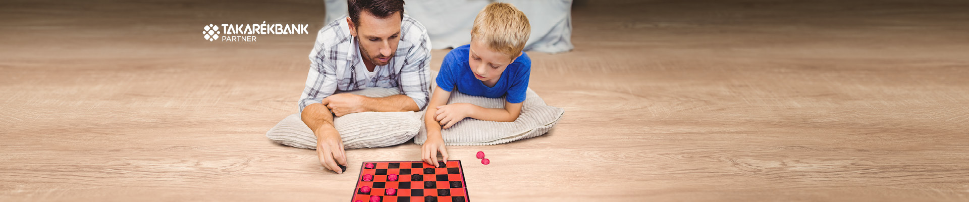A képen egy férfi és egy kisfiú látható, akik dáma társasjátékot játszanak.